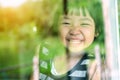 Asian child girl standing on glass mirror reflecting green forest