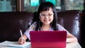Asian child girl studying homework and wearing face mask during her online lesson at home for protect  Covid-19 Royalty Free Stock Photo