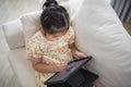 Asian child girl using pen and touch drawing on tablet display screen. Baby smiling funny time to use tablet. Too much screen time Royalty Free Stock Photo