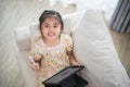 Asian child girl using pen and touch drawing on tablet display screen. Baby smiling funny time to use tablet. Too much screen time Royalty Free Stock Photo