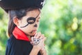 Asian child girl wearing halloween costumes and makeup making hands folded in prayer on Halloween celebration Royalty Free Stock Photo