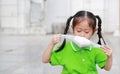 Asian child girl wearing a protection mask while outside to against PM 2.5 air pollution with pointing up in Bangkok city. Royalty Free Stock Photo