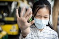 Asian child girl wearing protective mask at bus stop in the  city,show stop gesture,hand Royalty Free Stock Photo