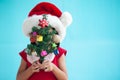 Asian child girl wearing santa hat and holding Christmas tree Royalty Free Stock Photo