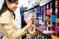 Asian child girl writing or experimenting with a pen on paper to buy,color pens on pen shelves in the shop,teenage student is Royalty Free Stock Photo