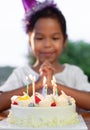 Asian child girls make folded hand to wish the good things for her birthday in birthday party Royalty Free Stock Photo