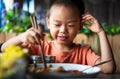 Asian child having lunch at the restaurant