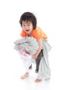 Asian child holding stack of t-shirts Royalty Free Stock Photo