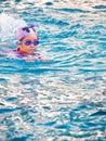 Asian child or kid girl wearing swimming suit to learning on swimming pool , learn and training swim on kick board Royalty Free Stock Photo