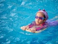 Asian child or kid girl wearing swimming suit to learning on swimming pool , learn and training swim on kick board Royalty Free Stock Photo