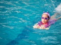 Asian child or kid girl wearing swimming suit to learning on swimming pool , learn and training swim on kick board Royalty Free Stock Photo