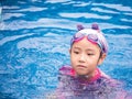 Asian child or kid girl wearing swimming suit to learning on swimming pool , learn and training swim on kick board Royalty Free Stock Photo