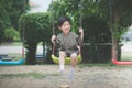 Asian child in kimono playing on swing i