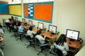 Asian elementary child learning to use computer in classroom.