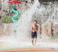 Asian child little boy having fun to play with water in park fountain in summer time Royalty Free Stock Photo