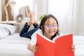 Asian child little girl reading books lying on the bed Royalty Free Stock Photo