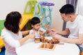 Asian child and parents playing with wooden blocks in the room at home. A kind of educational toys for preschool and kindergarten Royalty Free Stock Photo