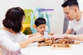 Asian child and parents playing with wooden blocks in the room at home. A kind of educational toys for preschool and kindergarten Royalty Free Stock Photo