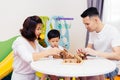 Asian child and parents playing with wooden blocks in the room at home. A kind of educational toys for preschool and kindergarten Royalty Free Stock Photo