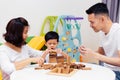 Asian child and parents playing with wooden blocks in the room at home. A kind of educational toys for preschool and kindergarten Royalty Free Stock Photo