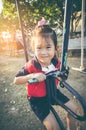 Asian child playing on manual carousel at children playground. Royalty Free Stock Photo