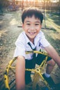 Asian child playing on manual carousel at children playground. Royalty Free Stock Photo