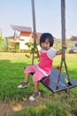 Asian child playing swing in the green mountain Royalty Free Stock Photo