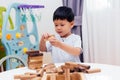 Asian child playing with wooden blocks in the room at home. A kind of educational toys for preschool and kindergarten kids Royalty Free Stock Photo