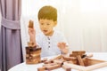 Asian child playing with wooden blocks in the room at home. A kind of educational toys for preschool and kindergarten kids. Royalty Free Stock Photo