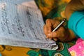 17.12.2022. asian child practicing handwritting with a pencil on copy . India