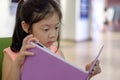 Asian Child Reading Book in Library