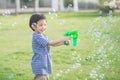 Asian child Shooting Bubbles from Bubble Gun Royalty Free Stock Photo