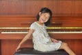 Asian child sits in front of piano