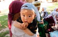 Asian child sitting on his mothers arms