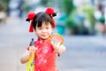 Asian child stood hugging yellow umbrella. Girl is looking at golden magnifying glass. Children smile sweet.