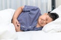 Asian child suffering from stomachache and lying on bed Royalty Free Stock Photo