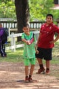 Asian child is throwing petanque ball.