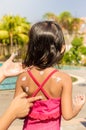 Asian Child Using Sunblock Lotion on Her Back Skin Before Swimmi