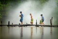 Asian children farmer on rice cross the wood bridge before the g Royalty Free Stock Photo