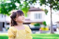 Asian children are happy  smiling sweet and staring at the sky. The background is a blurred house and a green lawn. Royalty Free Stock Photo