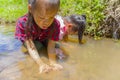 Asian Children playing barefoot in stream water, play mud and sand