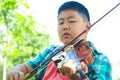 Asian boy playing violin music in the garden Royalty Free Stock Photo