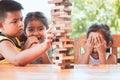 Asian children playing wood blocks stack game together with fun Royalty Free Stock Photo