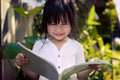 Asian children reading a book in home garden