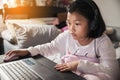 Asian children using laptop to learning and doing homework at home. Happy Thai Students study online for study to the exam. Royalty Free Stock Photo