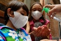 Asian children using liquid gel hand sanitizer