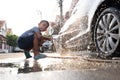 Asian children are using water hose to washing car Royalty Free Stock Photo