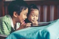 Asian children watching video and playing game on digital tablet Royalty Free Stock Photo
