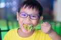 Asian children wear glasses with blue light blocking and eating