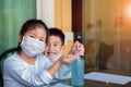 Asian children wearing face protection mask and cleaning hand by alcohol gel